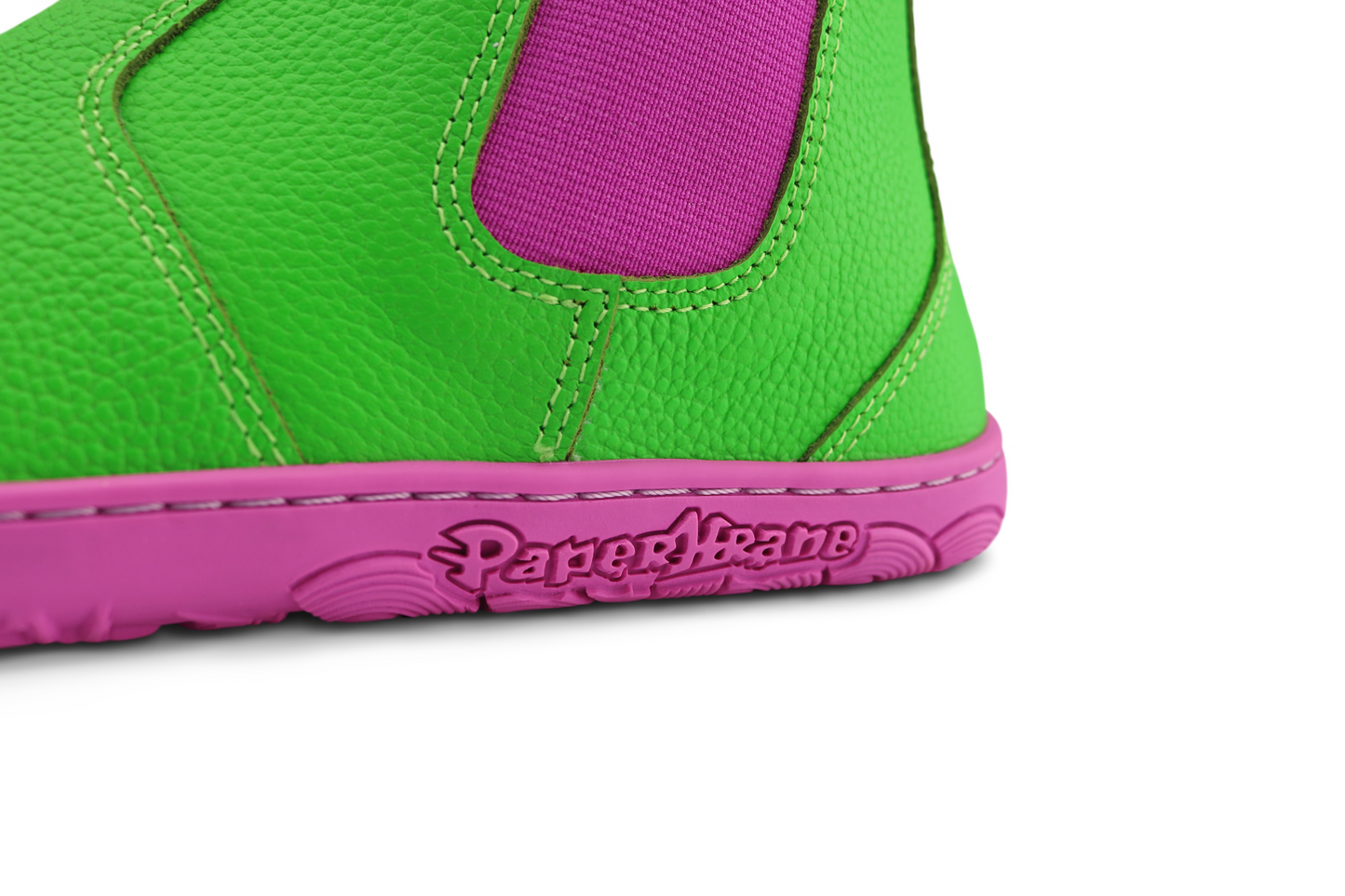 CLOSE UP VIEW OF THE PAPERKRANE LOGO ON PINK SOLE WITH GREEN BOOT