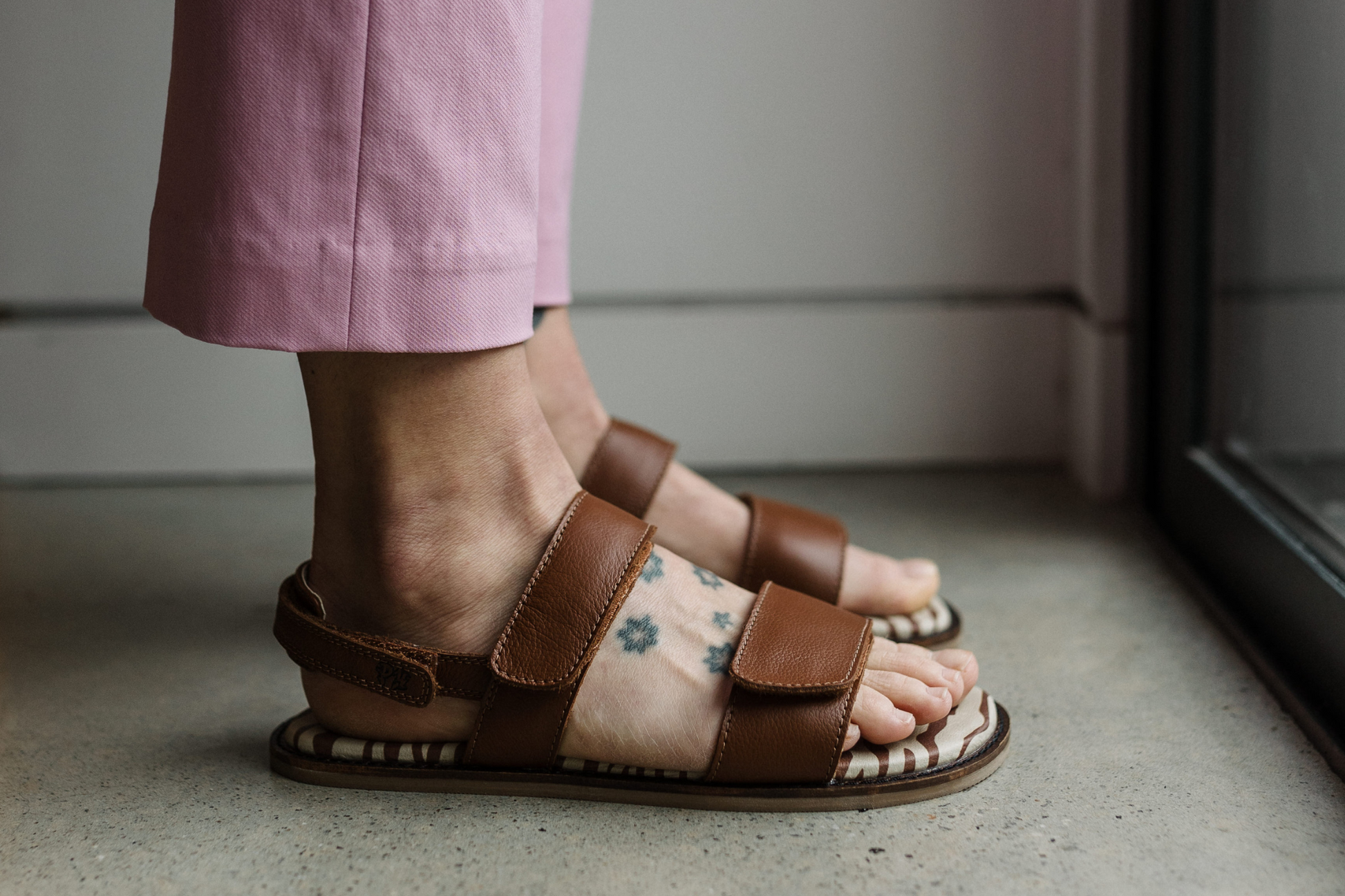 Side view of PaperKrane hot choc safari sandals on feet. 